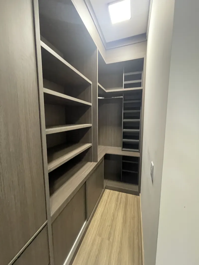 Closet planejado com prateleiras e nichos