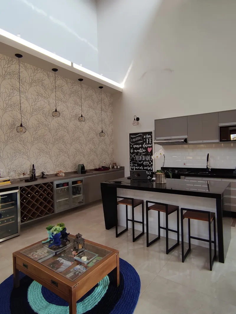 Cozinha aberta com bancada e banquetas em casa de campo