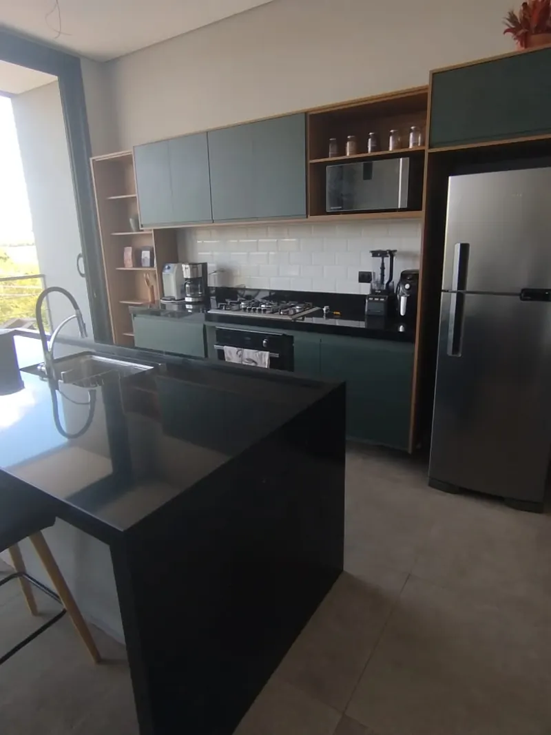 Cozinha integrada com ilha e bancada preta