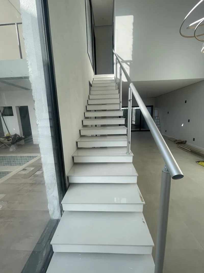 Escada de sobrado em porcelanato, com corrimão metálico