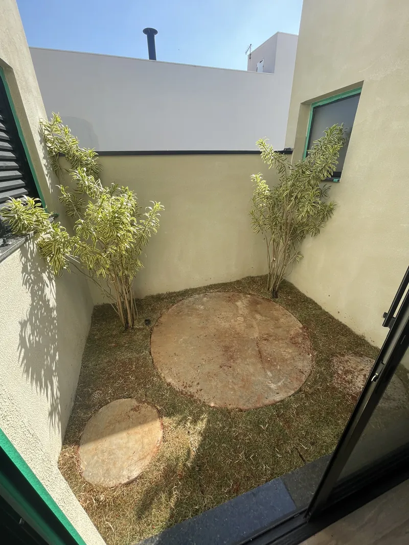 Jardim interno com pedras de piso e bambus