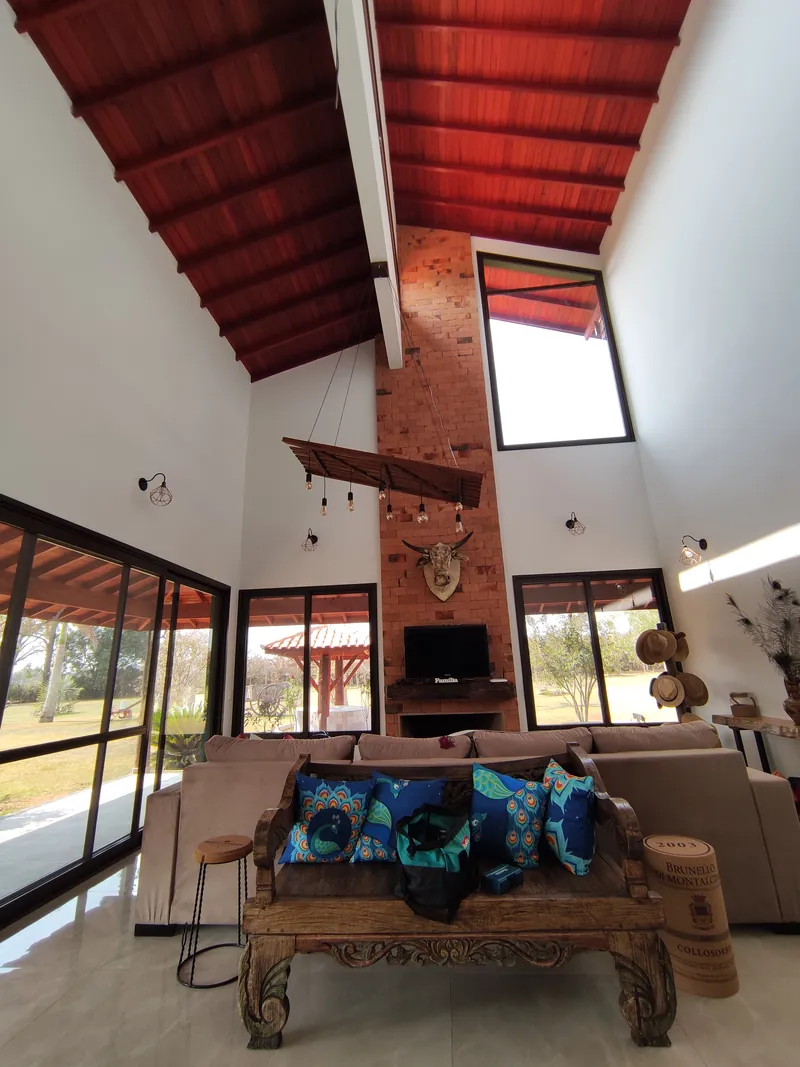 Sala com pé-direito duplo e telhado de madeira aparente